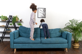 Good looking boy and girl play on the sofa