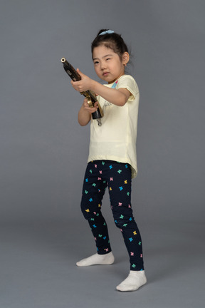 Portrait of a little girl aiming a shotgun