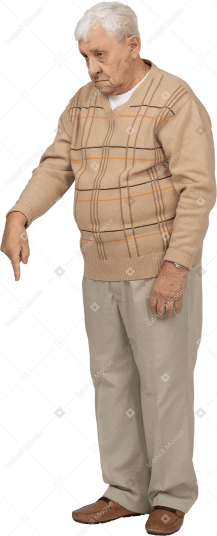 Front view of an old man in casual clothes pointing down with finger