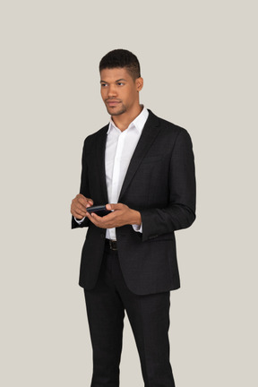 Young man in black suit holding calculator