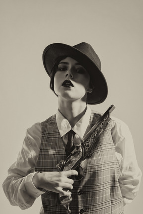 A woman wearing a hat and holding a gun