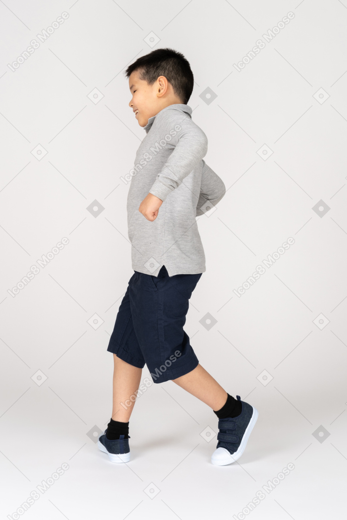 Little boy in profile is ready to kick something