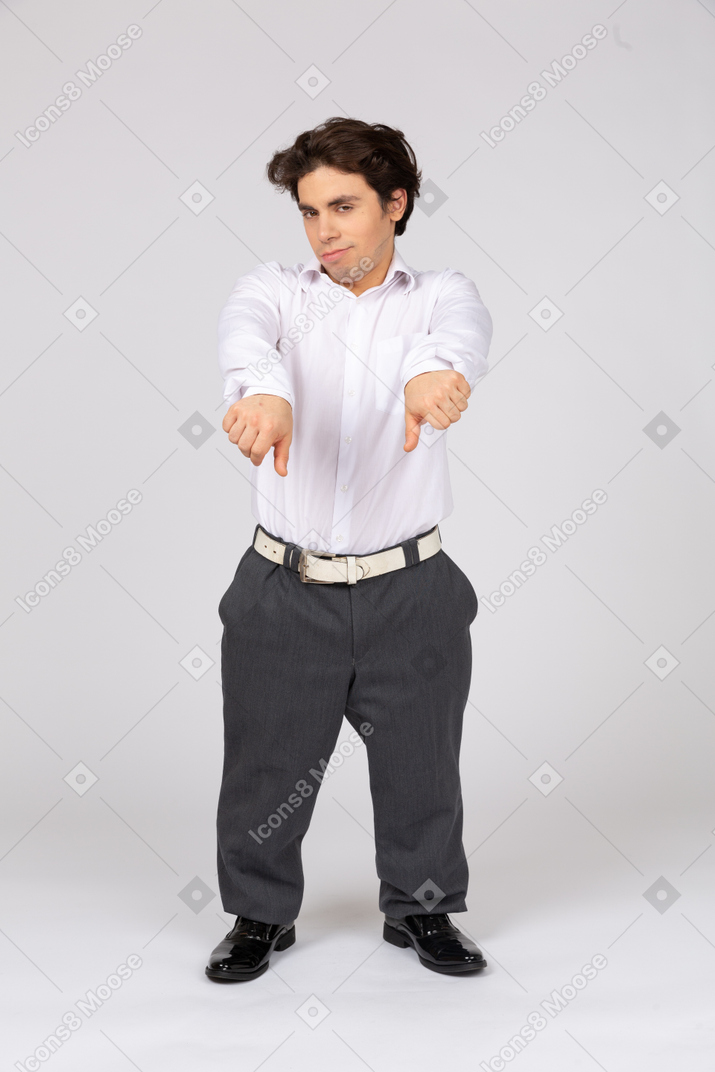 Young man in formalwear showing thumbs down