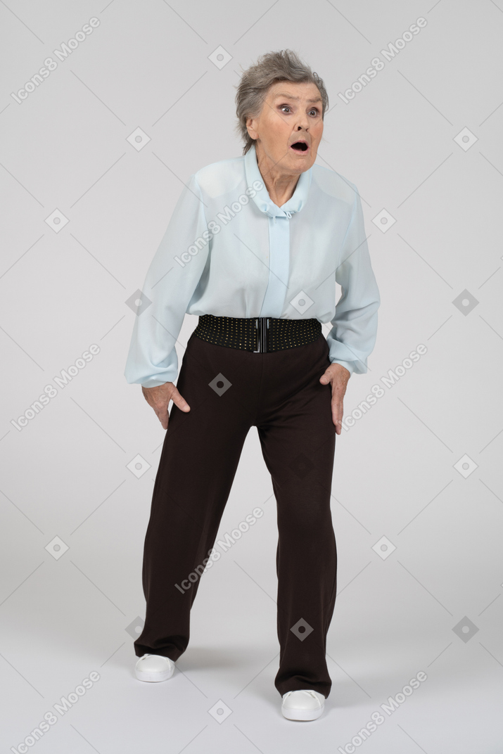 Three-quarter view of an old woman stepping forward looking shocked