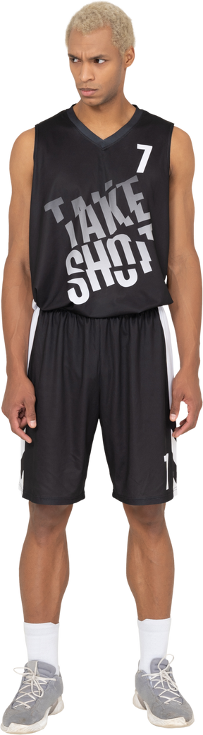 一个年轻的男篮球运动员低着头站立的前视图
