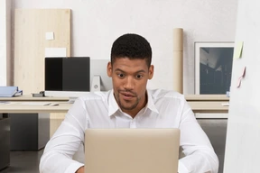 A man sitting in front of a laptop computer