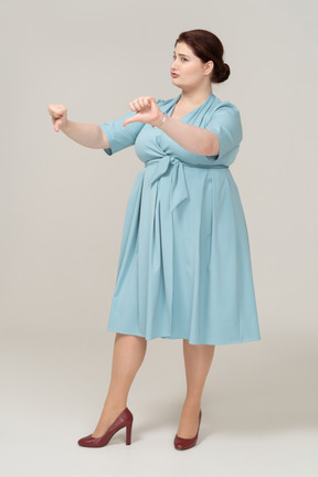 一个穿着蓝色裙子的女人的前视图，拇指朝下