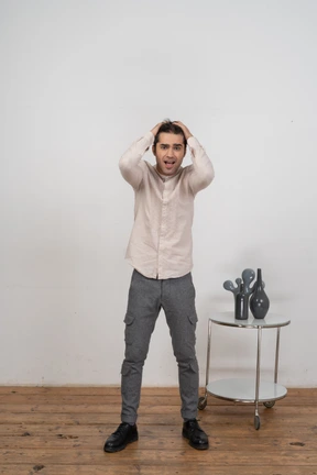 Man in shirt with hands behing head looking at camera