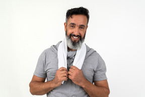 Smiling mature man holding white towel on his neck