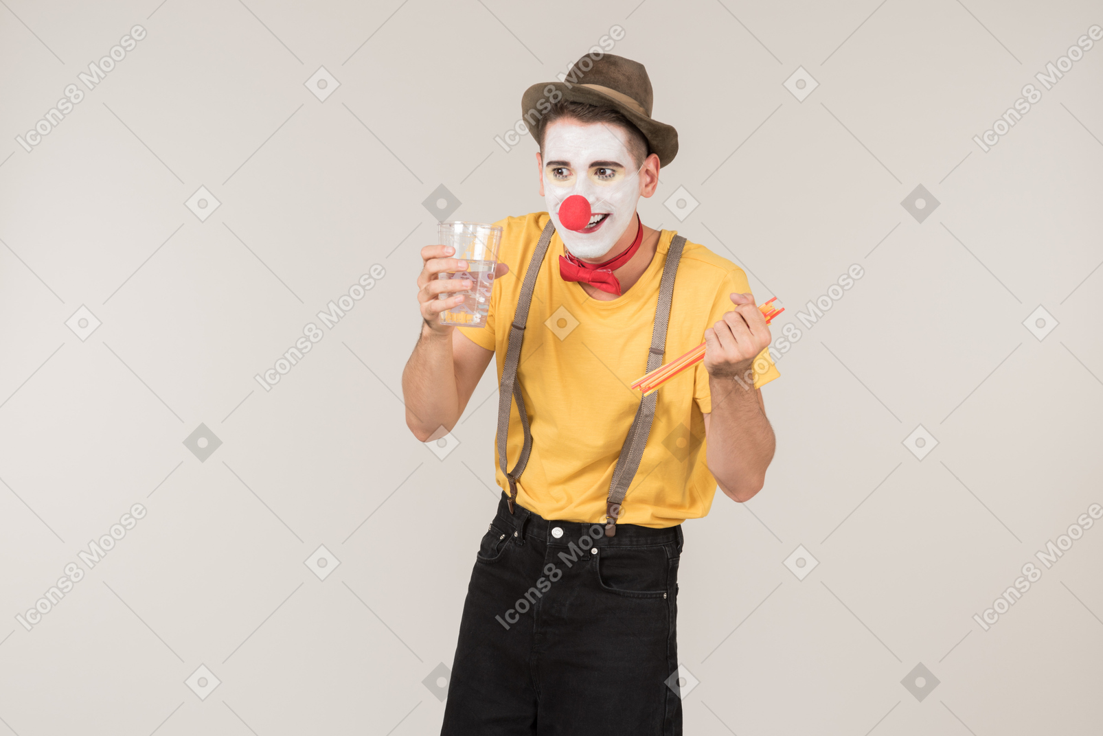 Male clown holding glass and straws