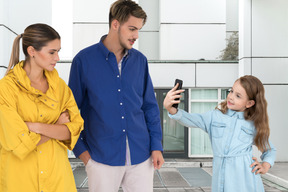 Parents watching their daughter taking a selfie