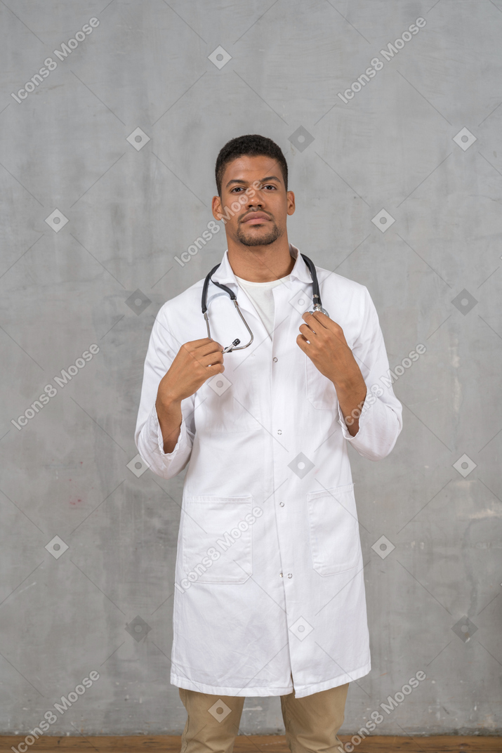 Vista frontal de un médico masculino con un estetoscopio