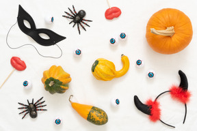 Different pumpkins, toy spiders, lollipops and a headband with horns