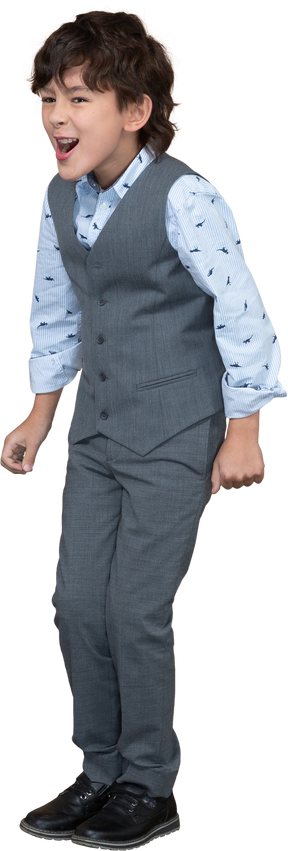 Angry boy in grey suit standing with clenched fist