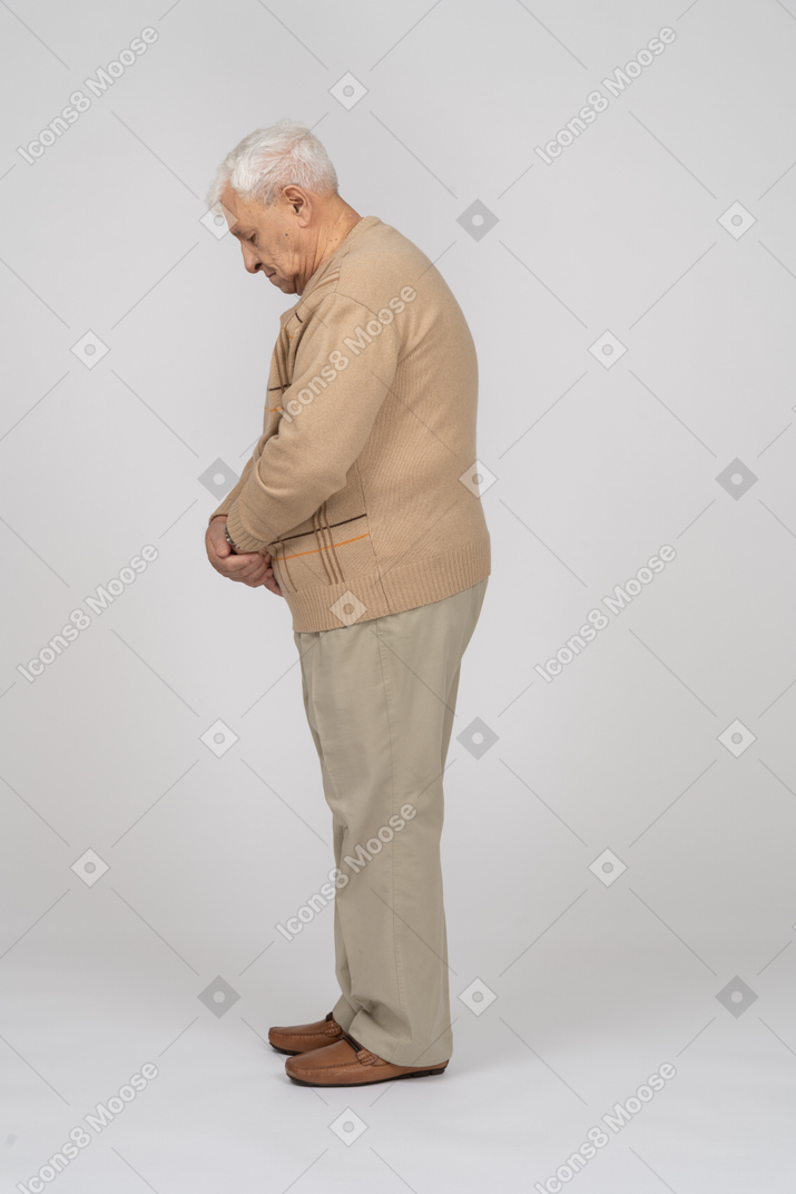 Vecchio in abiti casual in piedi di profilo
