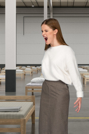 Woman standing in a room with beds and screaming