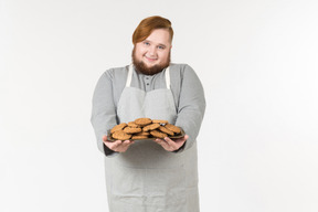 A smiling fat baker offering cookies