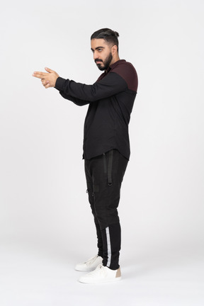 Young man with a bun aiming with finger gun