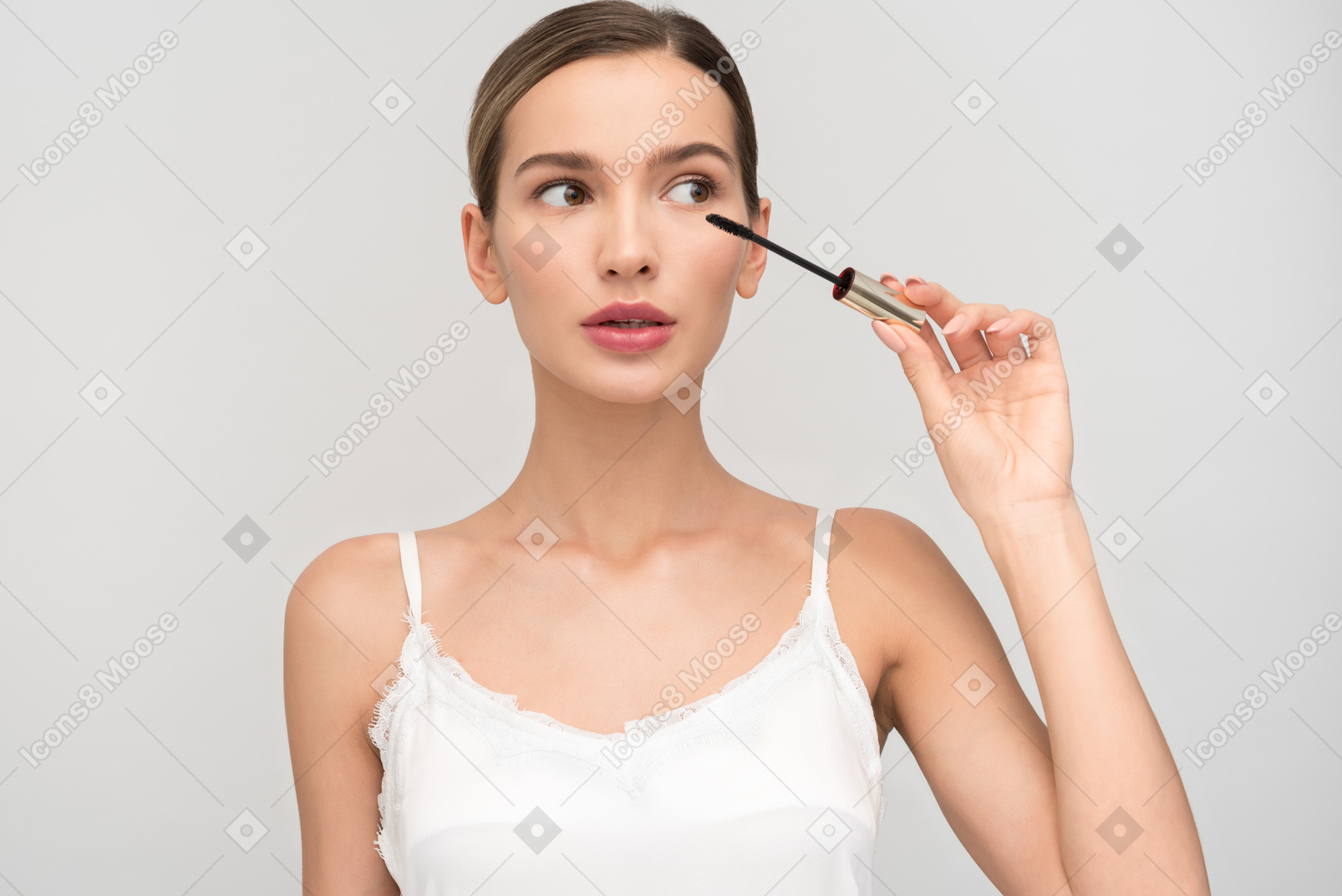 Beautiful young woman applying mascara