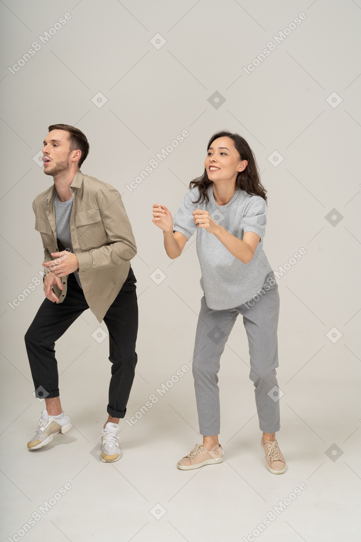 Man and woman doing a dance move side by side