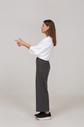 Vista laterale di una giovane donna in abiti da ufficio che fa uno scatto