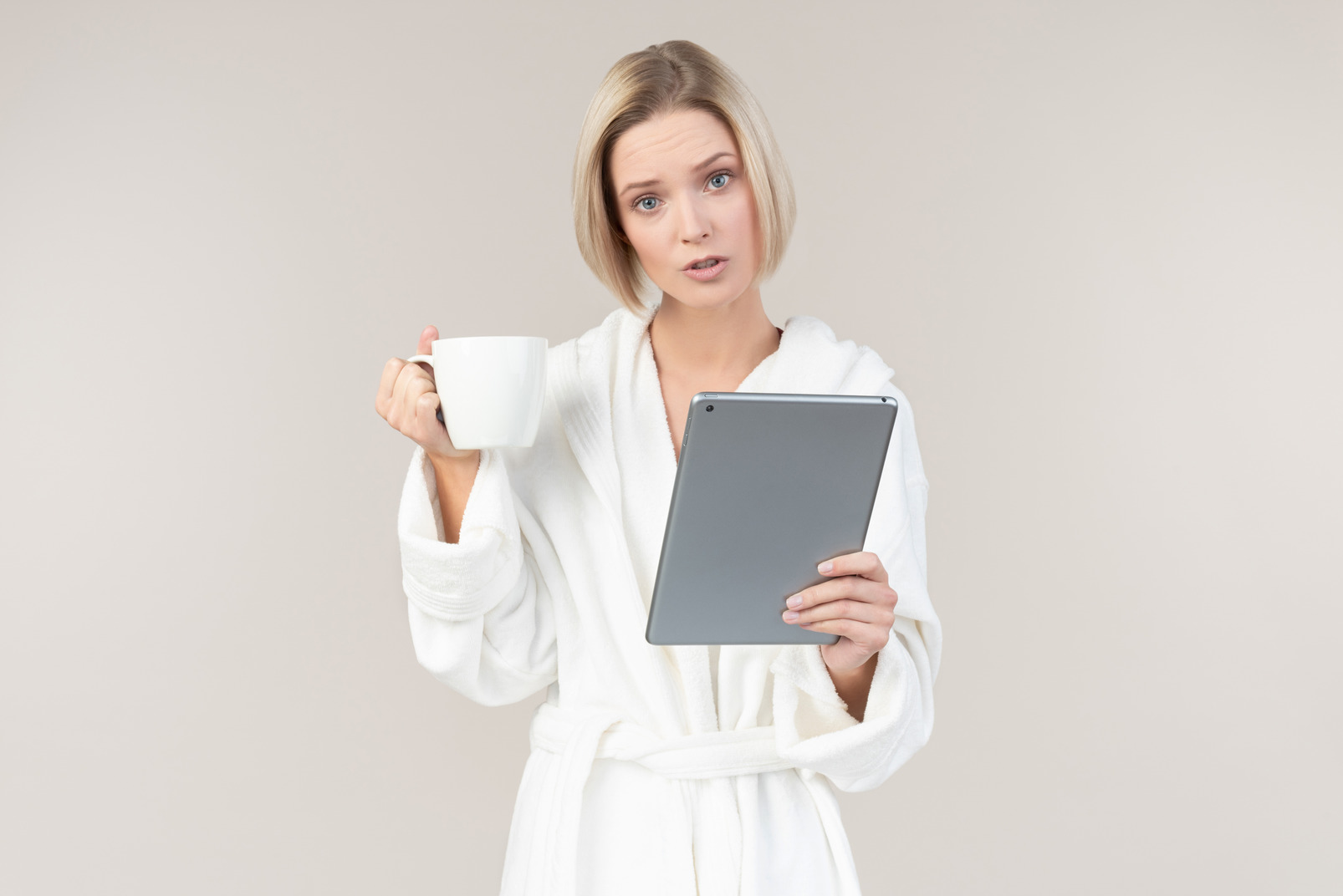 Young woman having coffee and using digital tablet