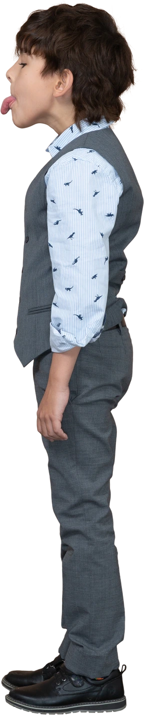Side view of a boy in grey suit showing tongue