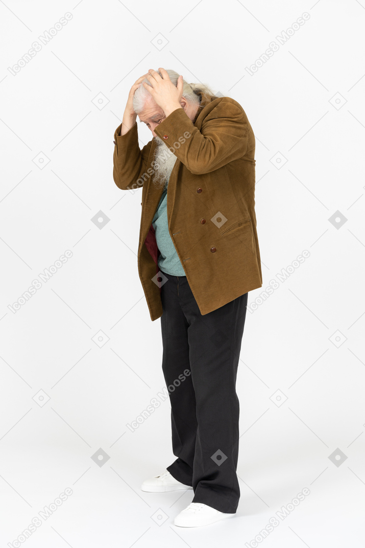 Elderly man holding his head and looking distressed