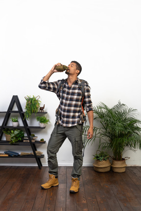 Full length of a tourist drinking from a flask