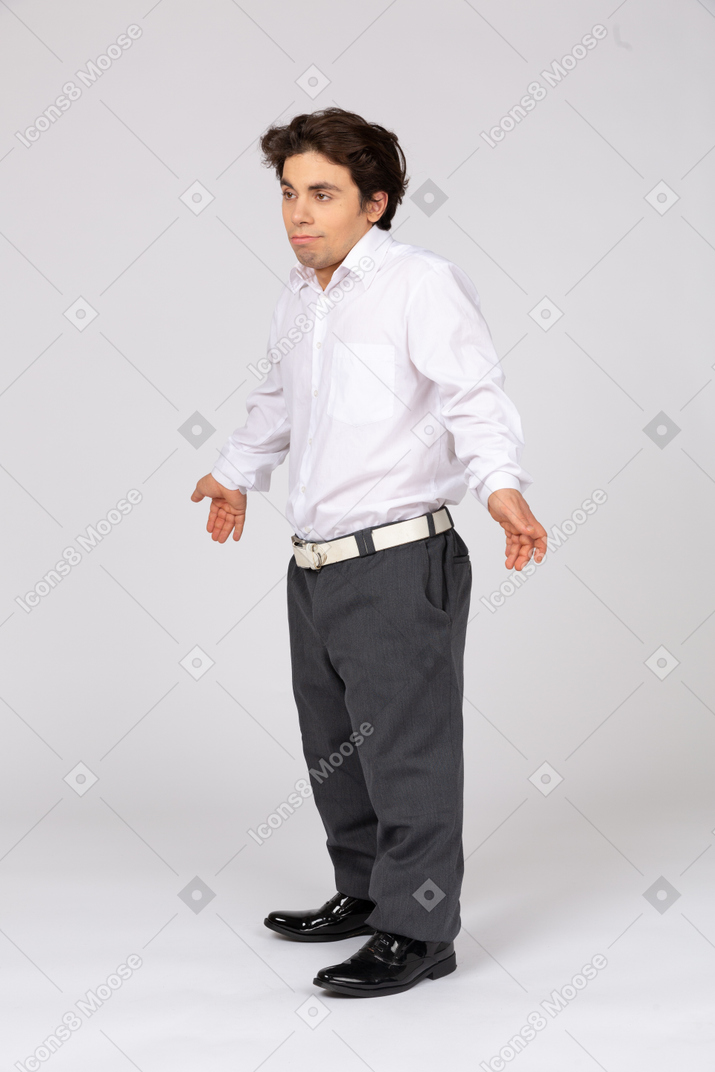Indifferent young man shrugging his shoulders