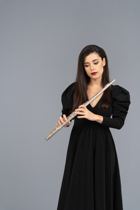 Front view of a young lady in black dress holding flute