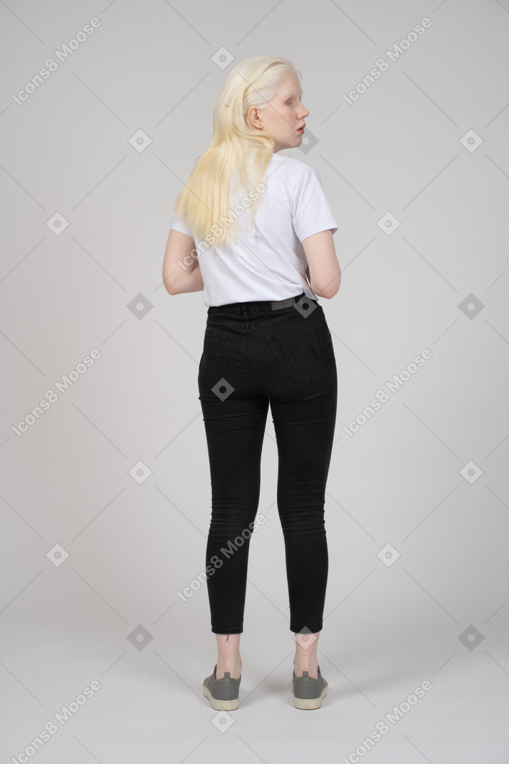 Vista posteriore di una giovane donna che guarda sopra la sua spalla