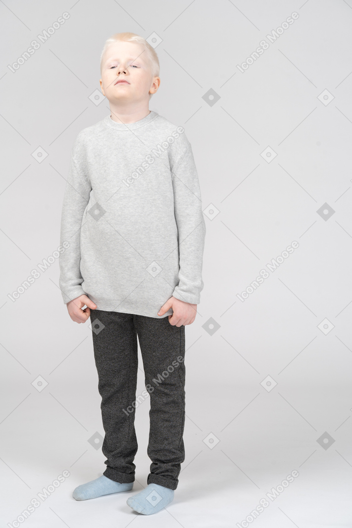 Front view of a tired kid boy in casual clothes