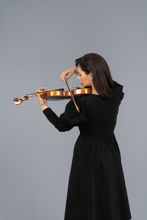 Close-up of a young lady in black dress playing the violin