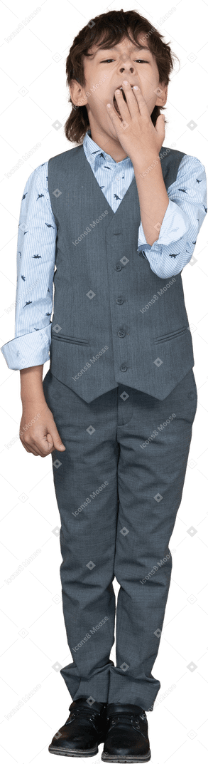 Vista frontale di un ragazzo in abito grigio che sbadiglia e si copre la bocca con la mano