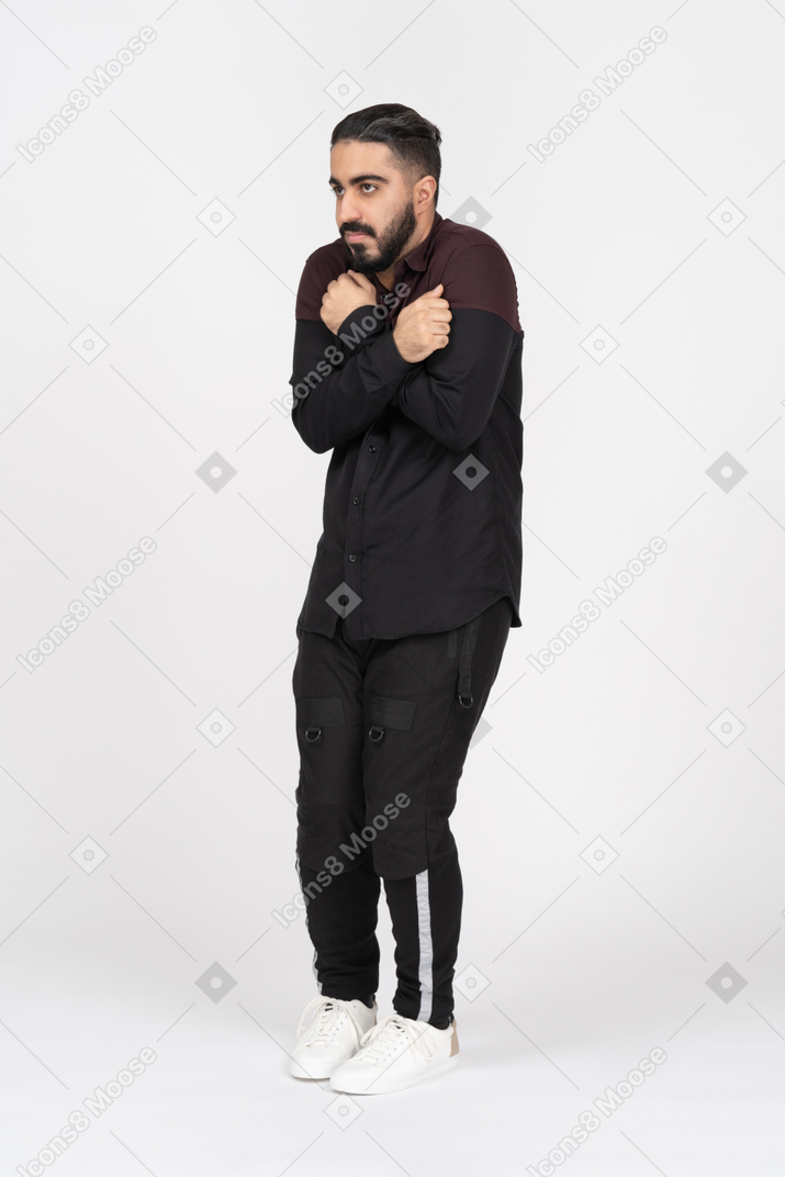 Shivering young man with crossed arms