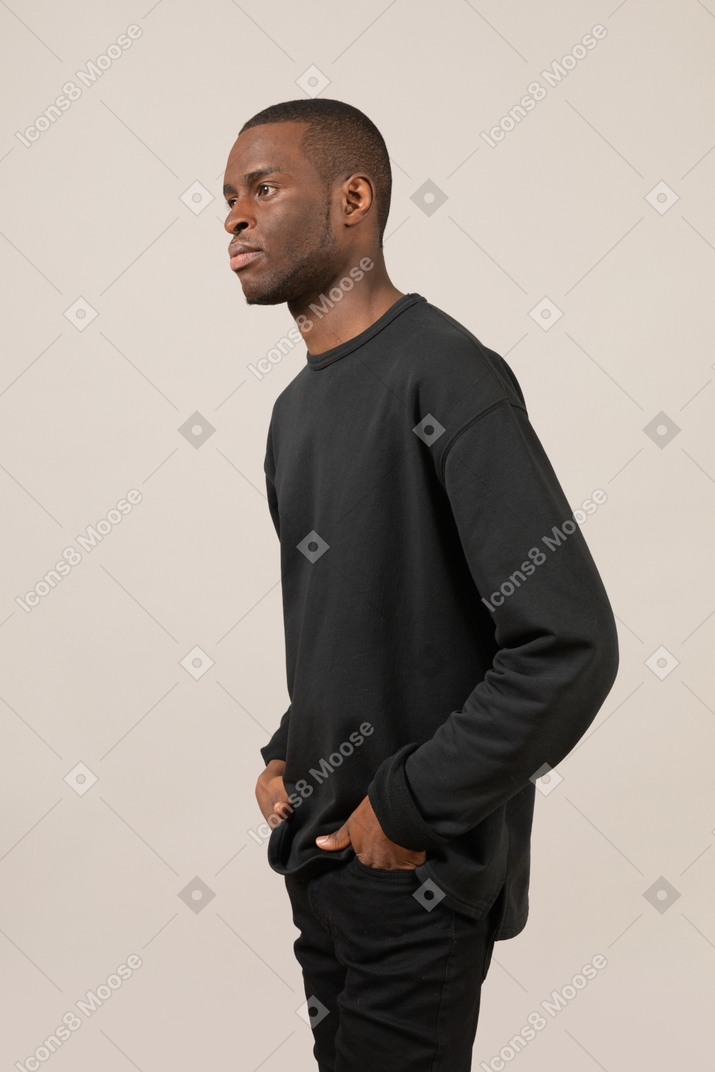 Side view of a guy keeping hands in pockets