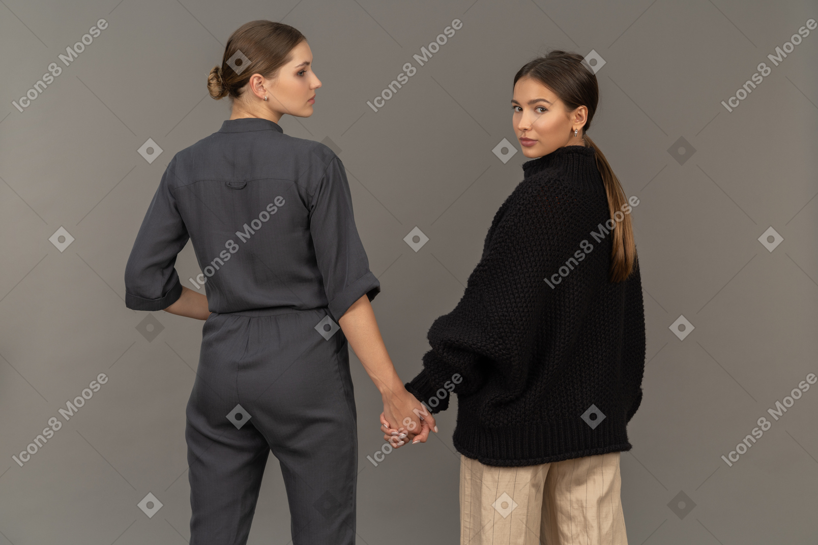 Back view of two women holding hands