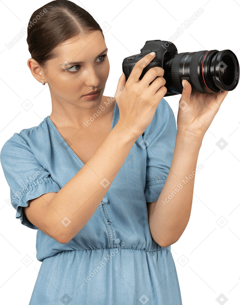 Vista di tre quarti di una giovane donna in abito blu che scatta una foto