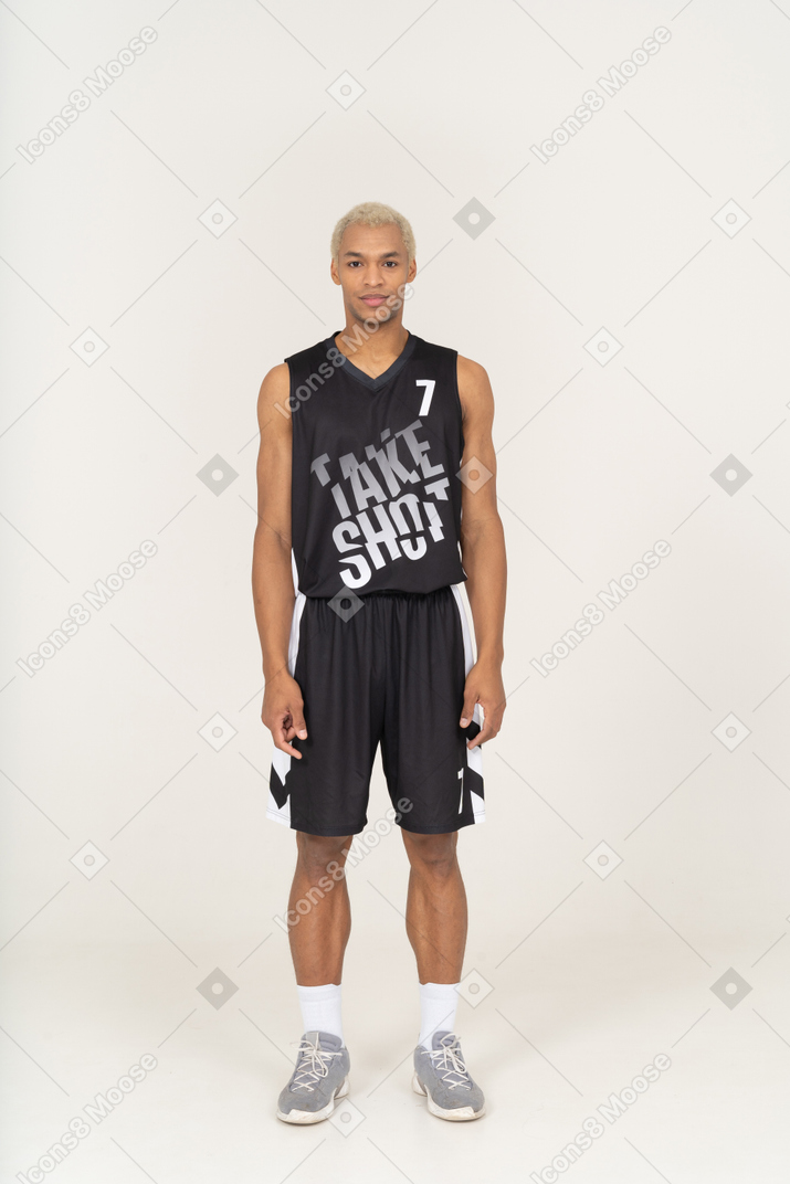 Vista frontale di un giovane giocatore di basket maschile che guarda la telecamera