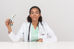 Beautiful female doctor holding scissors