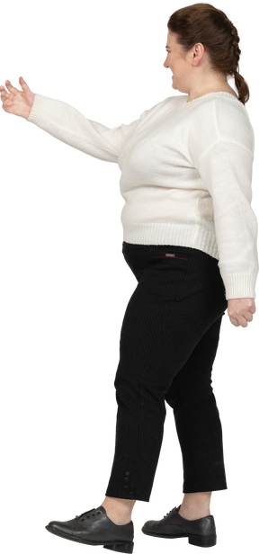 Felice donna grassoccia in maglione bianco in posa