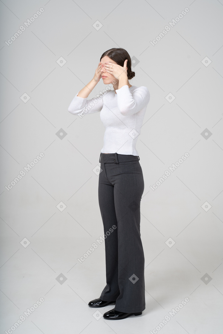Vista lateral de uma mulher cobrindo os olhos com as mãos