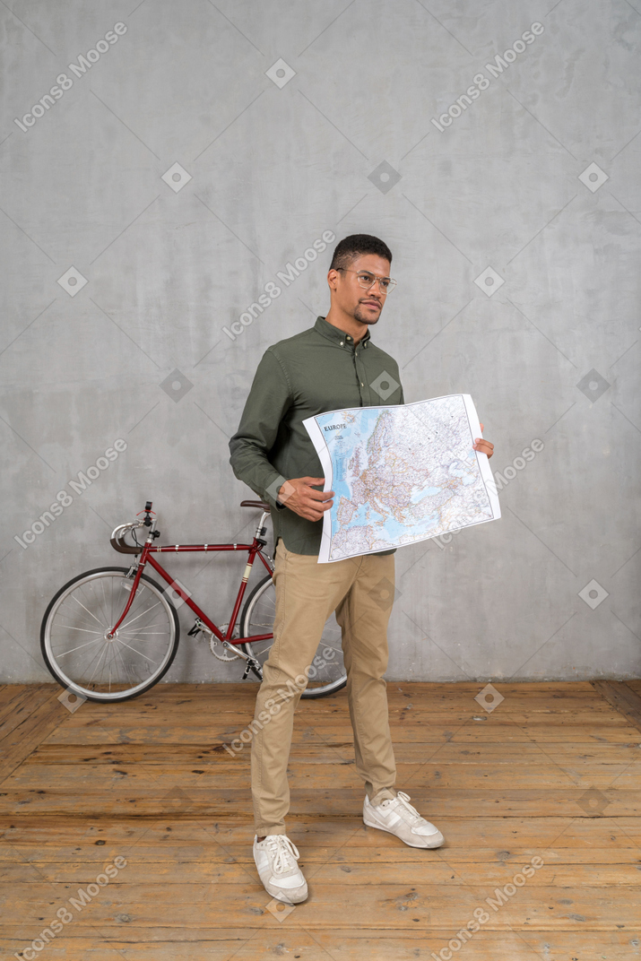 Visão de três quartos de um homem segurando um mapa