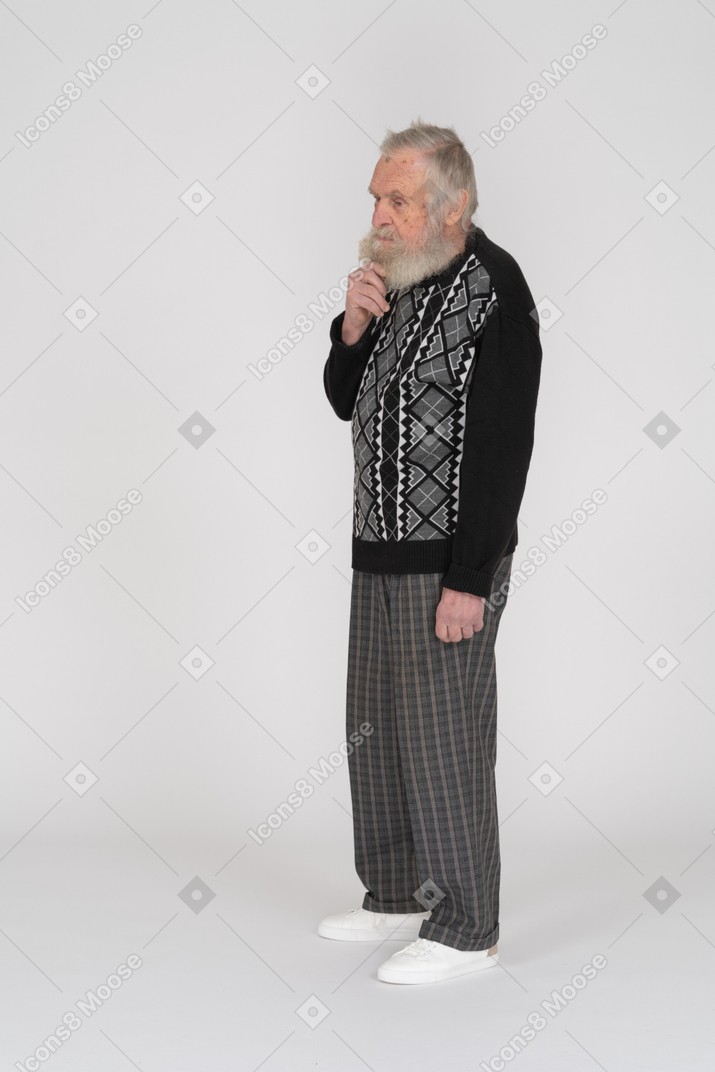 Vista de tres cuartos de un anciano sosteniendo su barba