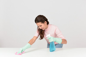 Attractive young woman dusting a surface