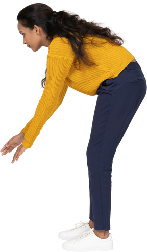 Side view of a girl in casual clothes bending down with extended arms