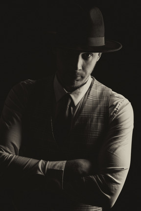 Dark portrait of a gentleman wearing a hat