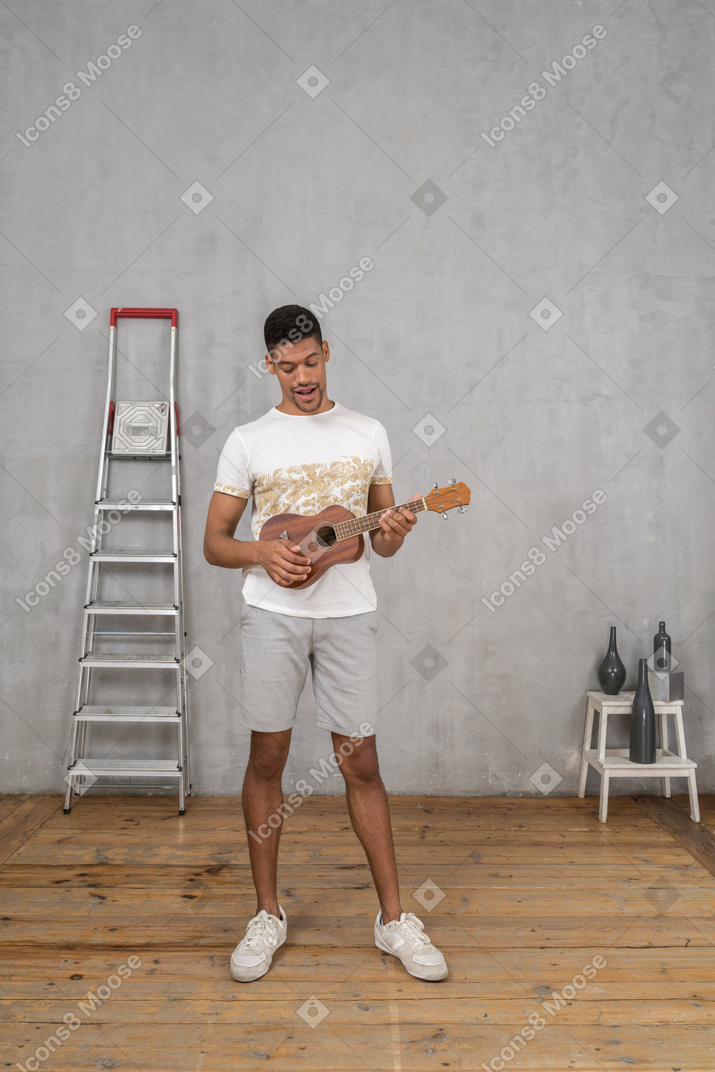 Vista frontale di un uomo che suona l'ukulele
