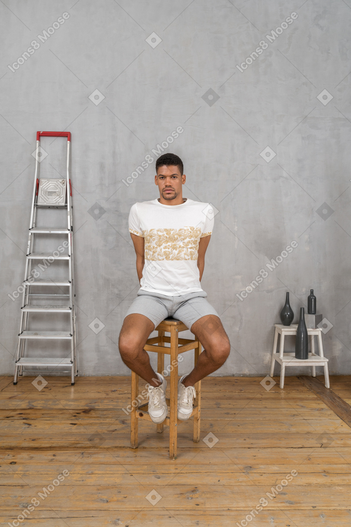 Man sitting with hands behind his back